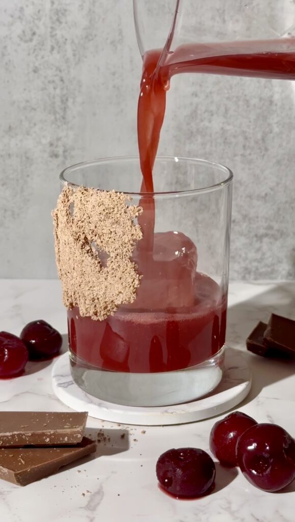 Pouring the combined ingredients over ice to make a delicious chocolate and cherry cocktail