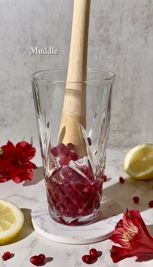 To get the juice out of the pomegranate seeds, muddle the seed with rum to form the base of the cocktail