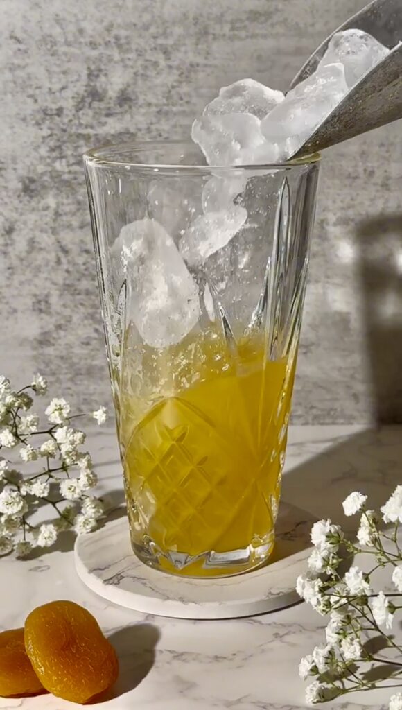 Shake the apricot and vodka cocktail mixture with ice before pouring it into a glass