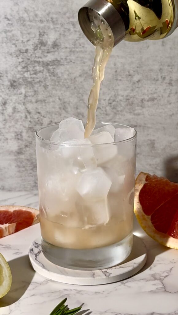 Pour the gin cocktail mixture over ice into a rocks glass